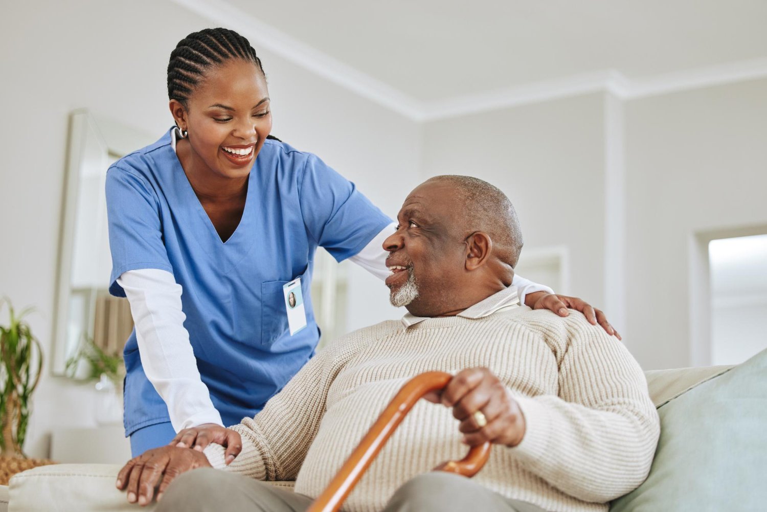 Caregiver supporting a smiling senior client at home